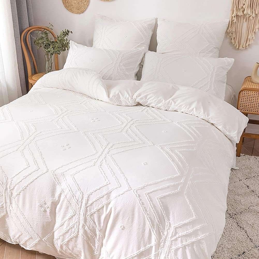 Close-up angled aerial view of the VibeCore Aesthetic Free Spirit Tufted Duvet Cover Set in white, highlighting the intricate tufted pattern and soft, textured fabric. This detailed shot emphasizes the cozy, boho-chic design, perfect for adding a touch of artistic flair and comfort to your bedroom or dorm.