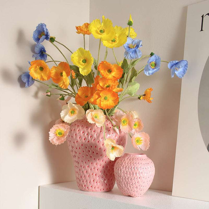VibeCore Cartoon Strawberry Ceramic Vase in light pink, showcasing both small and large sizes with vibrant flowers, adding a playful touch to any space with its quirky, hand-painted strawberry design.