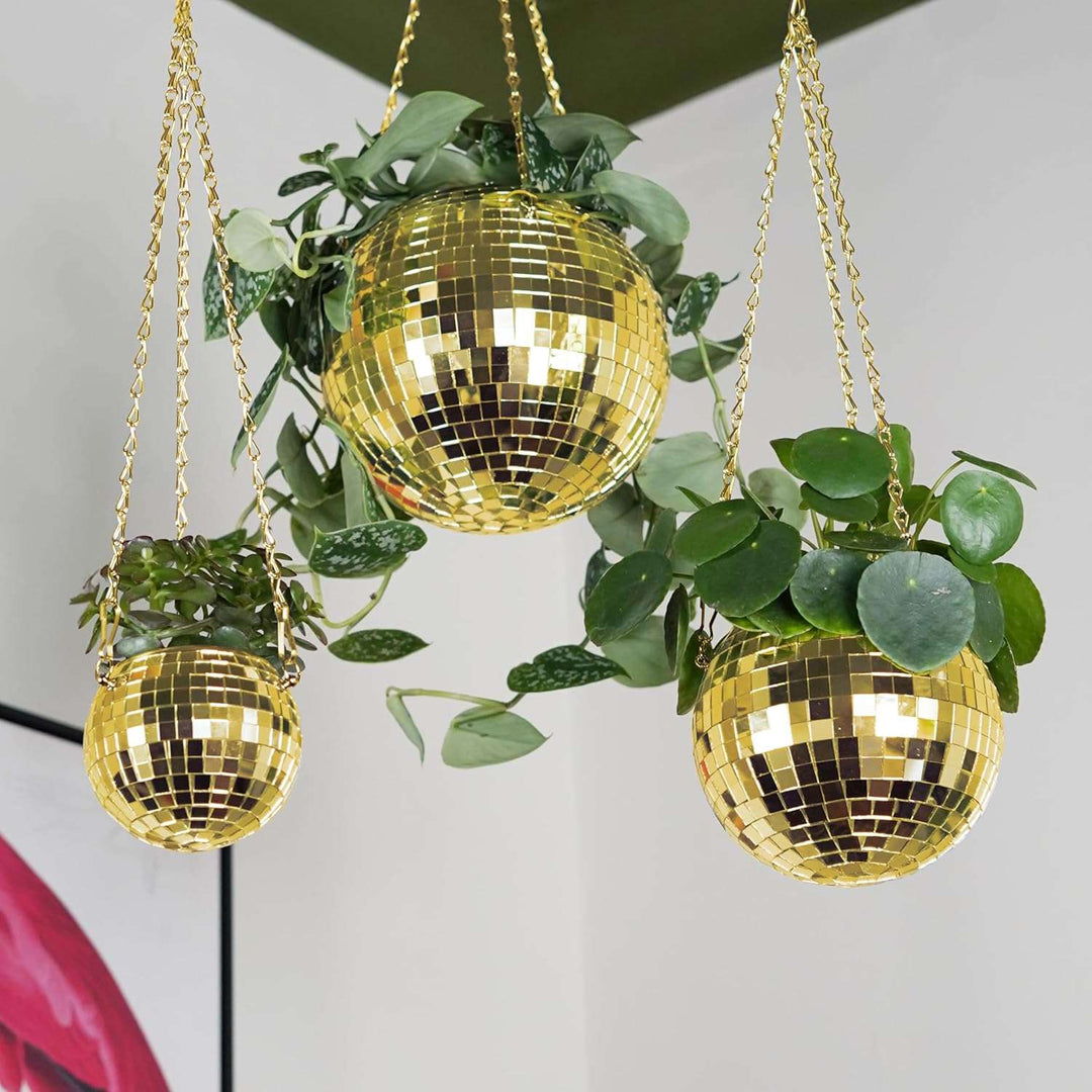 VibeCore Disco Ball Planter in gold, available in 3 sizes, hanging with a reflective mirror-ball surface. These retro-inspired planters add a luxurious, vibrant touch to your space while showcasing plants in a stylish, eye-catching display. Perfect for enhancing the decor of your living room, bedroom, or office with a playful and unique design.