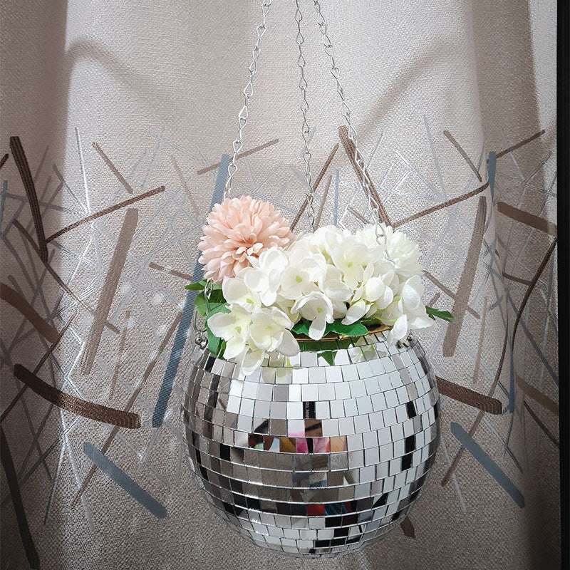 VibeCore Disco Ball Planter hanging with vibrant flowers, featuring a shiny, reflective mirror-ball surface. This unique planter adds a fun, retro vibe to any space while showcasing your plants in style. The disco ball design brings a playful touch, making it an eye-catching addition to your living room, bedroom, or garden.