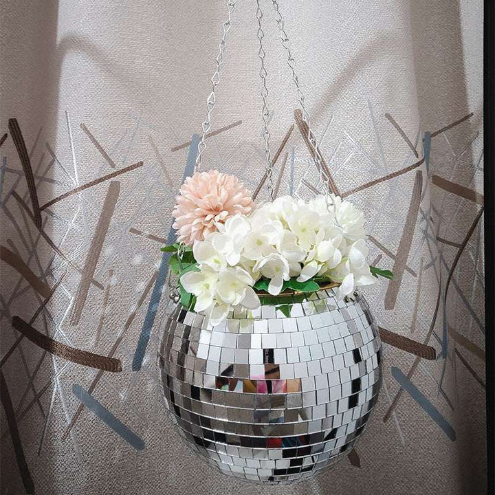 VibeCore Disco Ball Planter hanging with vibrant flowers, featuring a shiny, reflective mirror-ball surface. This unique planter adds a fun, retro vibe to any space while showcasing your plants in style. The disco ball design brings a playful touch, making it an eye-catching addition to your living room, bedroom, or garden.