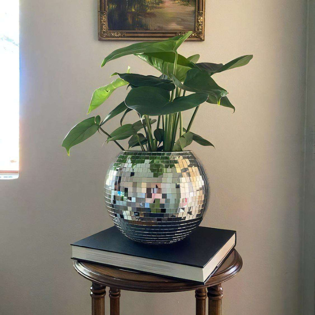 VibeCore Disco Ball Planter on side table, showcasing its shiny, reflective mirror-ball surface. This fun, retro-inspired planter adds a unique touch to any room while serving as a stylish home for your plants. The disco ball design brings an eclectic vibe, perfect for enhancing your living room, bedroom, or office decor.