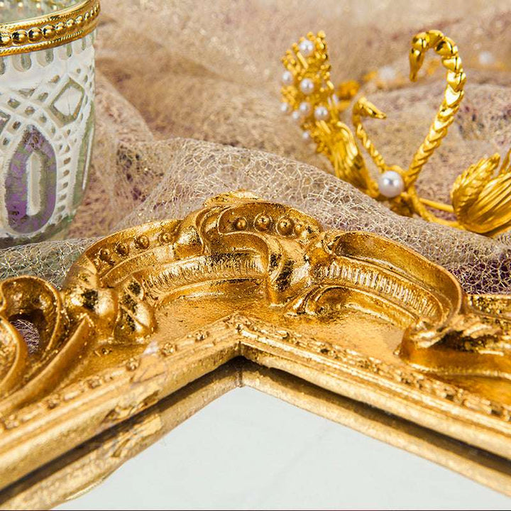 Close-up of intricate gold detailing on the reflective surface, adding a touch of elegance and luxury to any decor.