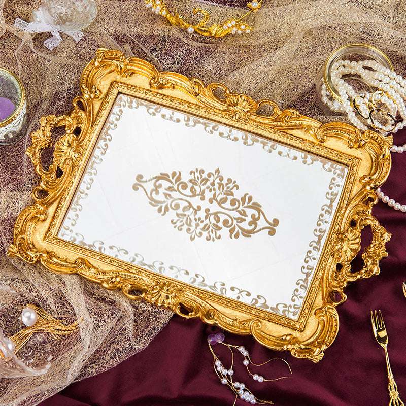 Aerial view of a luxurious gold mirror tray with intricate gold detailing and a reflective surface. Perfect for coquette aesthetic decor, displaying jewelry, perfumes, or desserts. Featuring a soft flannel base and elegant gold accents, this tray adds vintage charm and sophistication to any space.