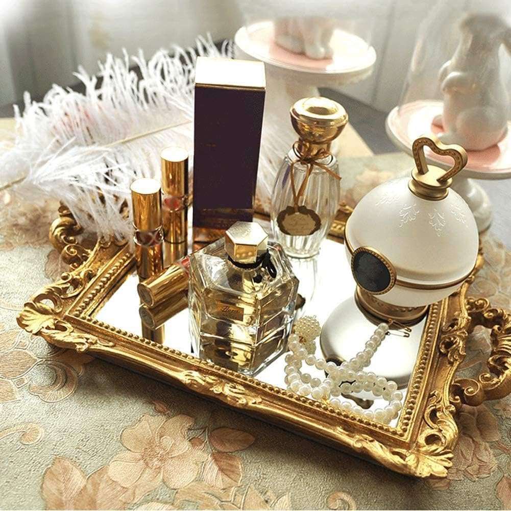 Elegant gold mirror tray with a reflective surface, adorned with perfumes. Perfect for adding a touch of sophistication to any space.