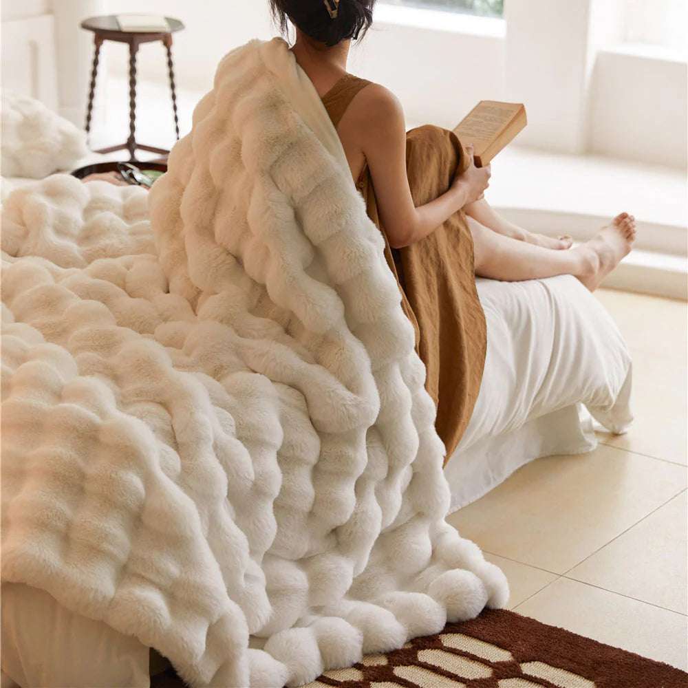 VibeCore Marshmallow Ultra Plush Blanket White Over A Woman's Shoulders while she is reading and cozy in her bed