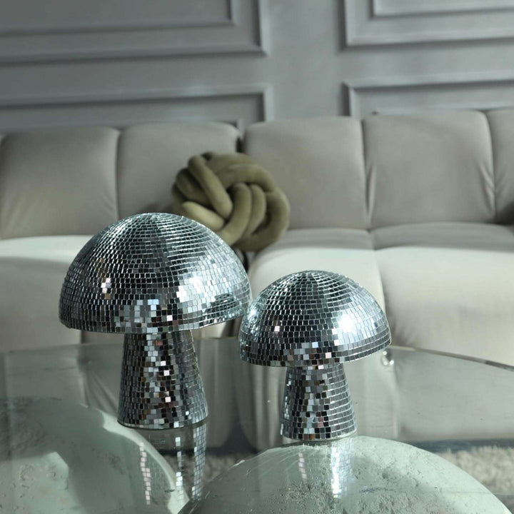 Two VibeCore Mushroom Disco Balls on a living room coffee table, casting vibrant light patterns and adding a playful, retro touch to the modern decor. The mushroom-shaped disco balls reflect light beautifully, creating an eye-catching ambiance in the room.