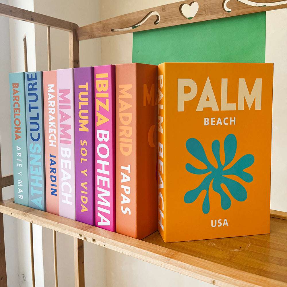 VibeCore Preppy Cities Fake Book Storage Box with city-themed design, placed on a bookshelf in a preppy and pastel-inspired room. Ideal for organizing jewelry, stationery, or small keepsakes, combining chic, sophisticated decor with practical storage.