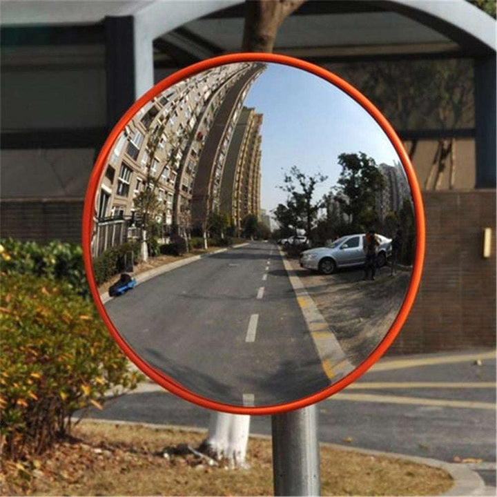 VibeCore Red Convex Traffic Mirror on road, designed as a functional traffic mirror. Featuring a bold red frame and wide-angle lens, this convex mirror provides a clear reflection, enhancing visibility and safety. Its sleek, urban design makes it a striking addition to the roadway while offering practical use.