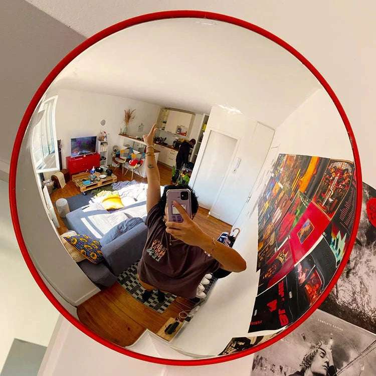 VibeCore Red Convex Traffic Mirror in living room, featuring a bold red frame and wide-angle lens for perfect selfies. This modern fish eye mirror adds a trendy, urban vibe with its sleek convex design, offering a clear reflection and an edgy, industrial-style accent to the space.