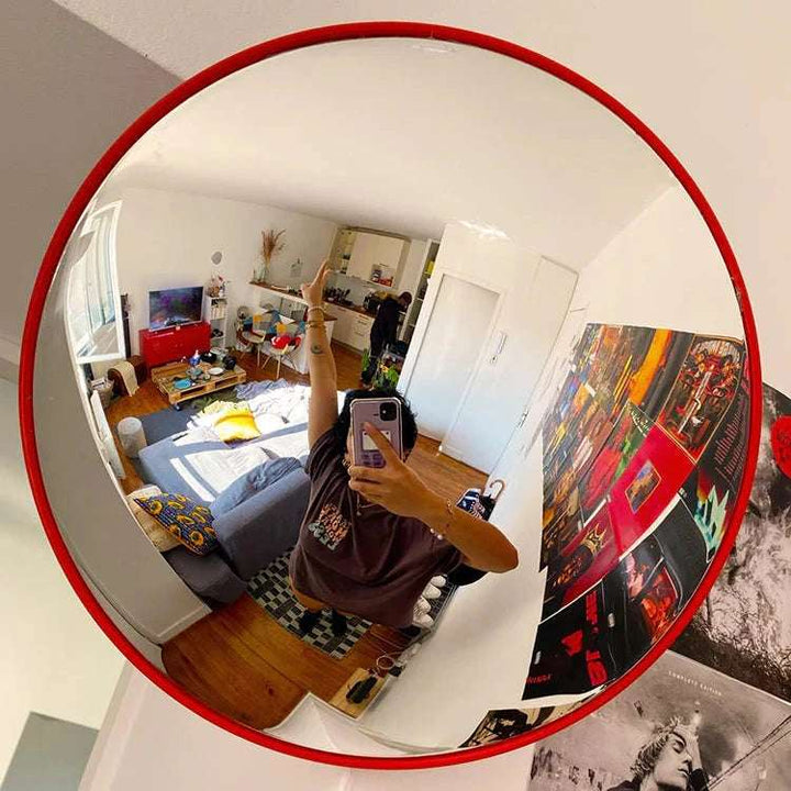 VibeCore Red Convex Traffic Mirror in living room, featuring a bold red frame and wide-angle lens for perfect selfies. This modern fish eye mirror adds a trendy, urban vibe with its sleek convex design, offering a clear reflection and an edgy, industrial-style accent to the space.