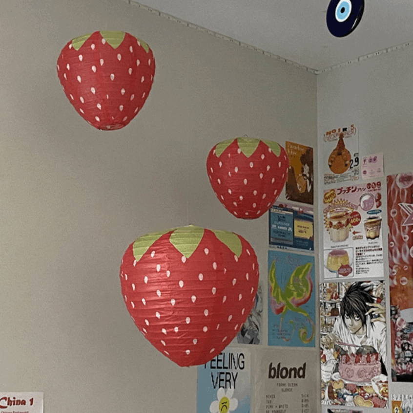 VibeCore Strawberry Paper Lantern Pendant hanging in a room, casting a warm, playful glow with its cute strawberry design and vibrant colors, adding a whimsical touch to the space.