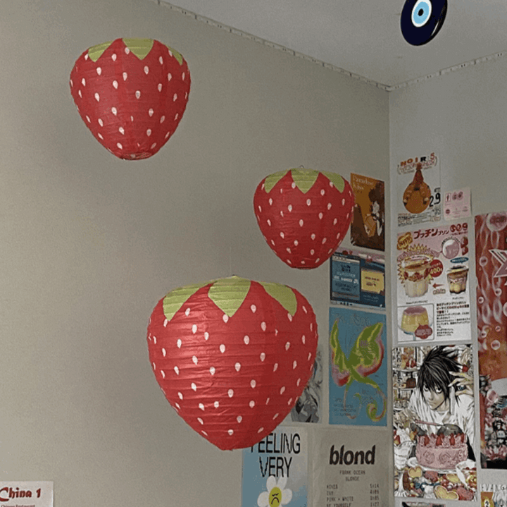 VibeCore Strawberry Paper Lantern Pendant hanging in a room, casting a warm, playful glow with its cute strawberry design and vibrant colors, adding a whimsical touch to the space.