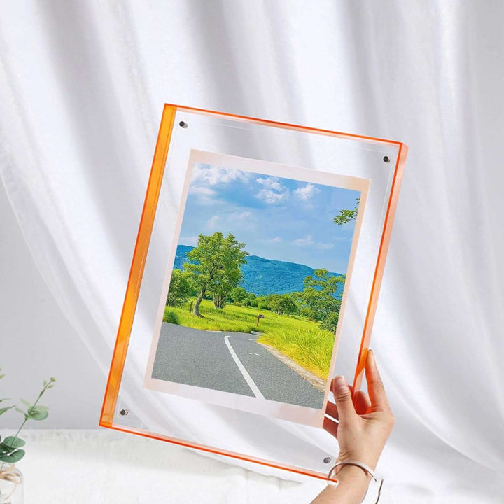 VibeCore Transparent Acrylic Photo Frame held by a woman—showcasing a sleek, modern design with its clear acrylic construction. This minimalist frame adds a touch of elegance to any room, making it perfect for displaying cherished moments in a contemporary style.