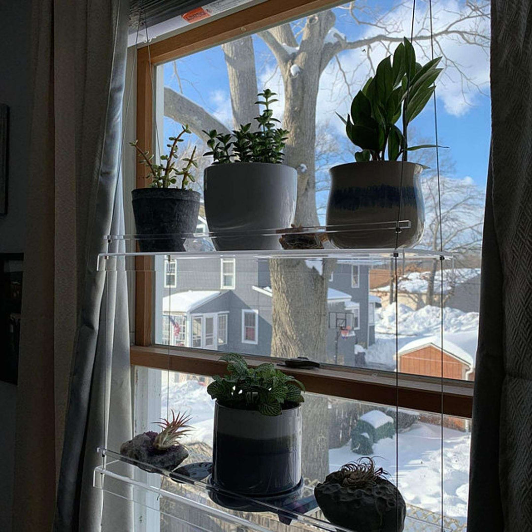 VibeCore Transparent Hanging Plant Shelf with 2 shelves, angled view showcasing its sleek acrylic design and adjustable cords, perfect for displaying plants in style.