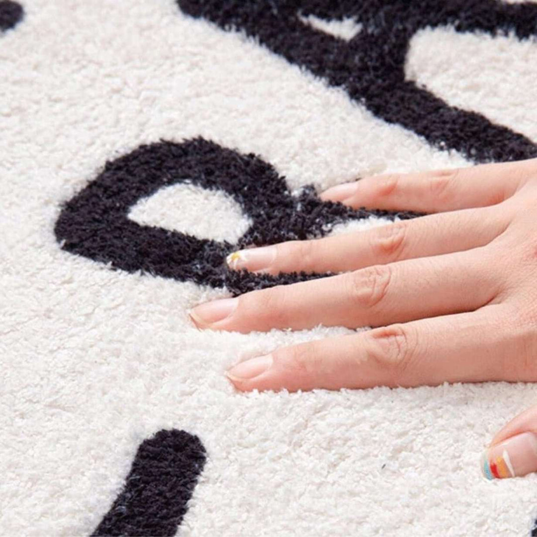 Close-up of the VibeCore White No Music Is Life Accent Rug material, showcasing its soft, durable fabric and smooth texture. The high-quality material ensures comfort and longevity while complementing the minimalist design with bold typography, making it a perfect fit for any modern, music-inspired space.