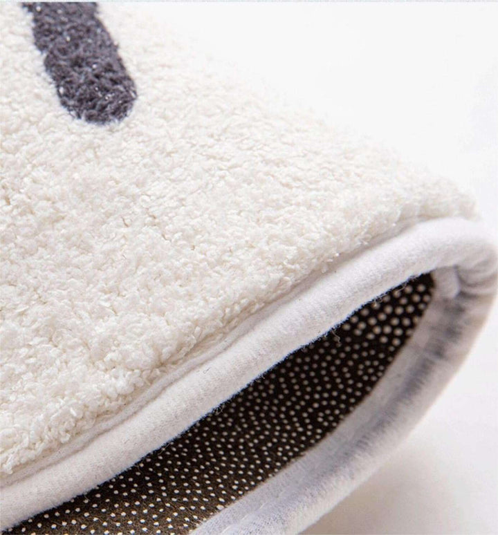 Close-up of the VibeCore White No Music Is Life Accent Rug, highlighting its plush thickness and soft texture. The rug's thick surface offers comfort while maintaining its sleek, minimalist design with bold typography and a modern, music-inspired aesthetic.