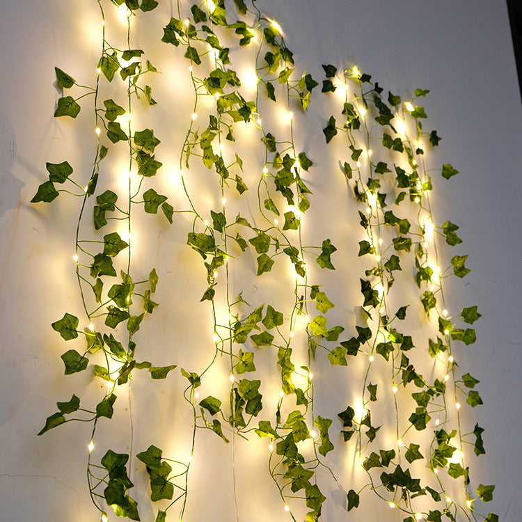 Leaf vine string lights hanging on wall, aesthetic room decor.