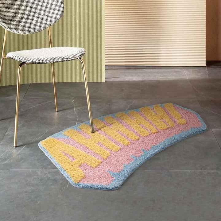 VibeCore AHHHH! Accent Rug on the floor with a chair leg resting on it, showcasing the bold and playful design that adds a fun, energetic touch to the room. The non-slip backing keeps it securely in place.