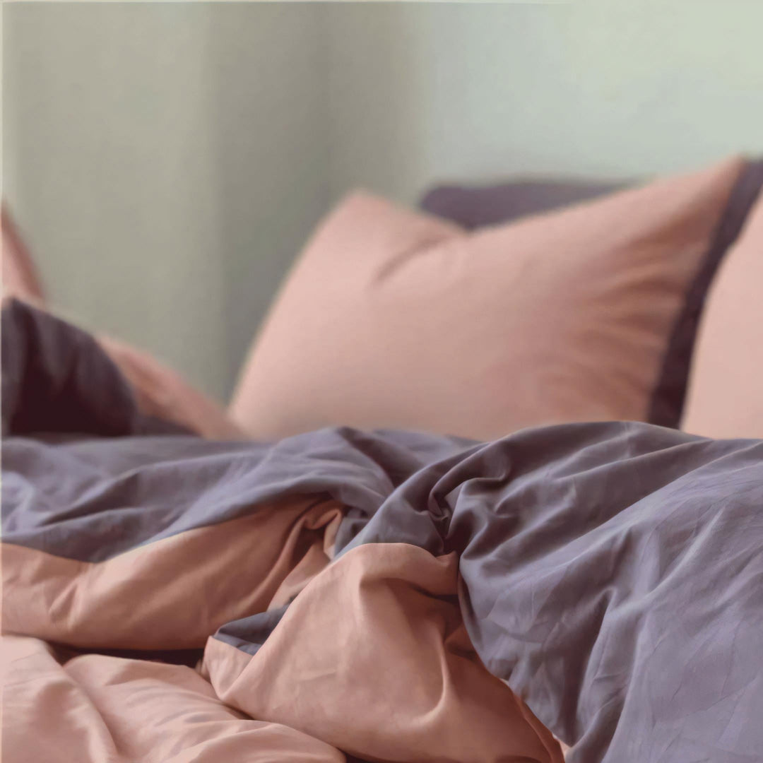 Close-up of the VibeCore Aesthetic Australian Cotton Duvet Cover Set Light Pink sheet, highlighting the soft, breathable texture of the premium Australian cotton fabric. The subtle pink outer hue and deep purple inner hue adds a delicate touch to your bedroom, offering a blend of comfort and elegance that's perfect for year-round use.