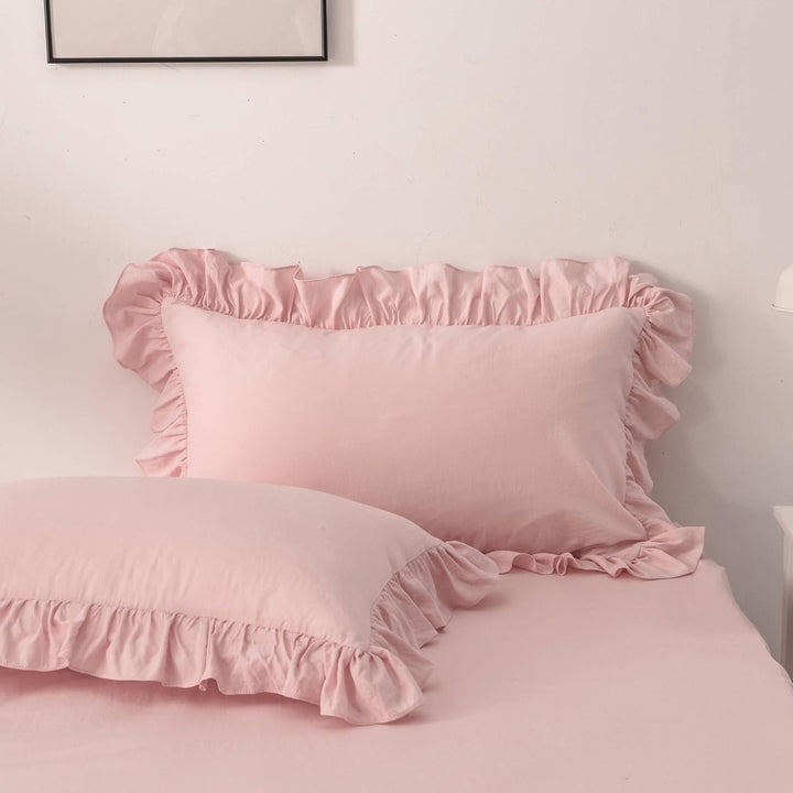 Close-up of the pillowcases from the VibeCore Aesthetic Elegant Ruffles Duvet Cover Set in baby pink, showcasing the soft ruffle details and smooth, breathable fabric. A stylish and cozy accent to elevate any bedroom or dorm decor.