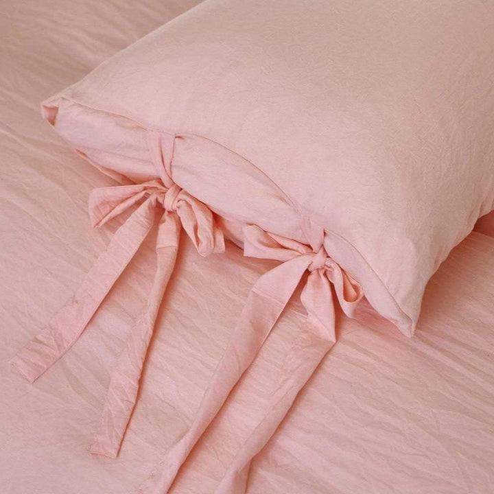 Close-up of the intricate knot detail on the baby pink duvet cover from the VibeCore Aesthetic Knot So Ordinary Duvet Cover Set, highlighting the unique texture and stylish design for a cozy, chic bedroom or dorm look.
