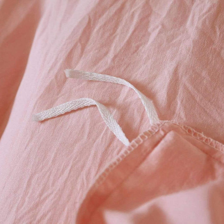 Close-up of the stylish tie feature on the baby pink duvet cover from the VibeCore Aesthetic Knot So Ordinary Duvet Cover Set, showcasing the trendy design detail that adds a unique, fashionable touch to your bedding.
