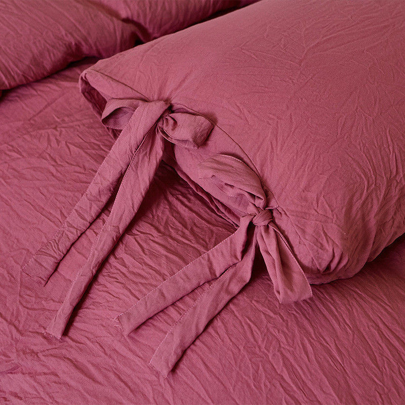 Close-up of the intricate knot detail on the dusty rose duvet cover from the VibeCore Aesthetic Knot So Ordinary Duvet Cover Set, highlighting the unique texture and stylish design for a cozy, chic bedroom or dorm look.