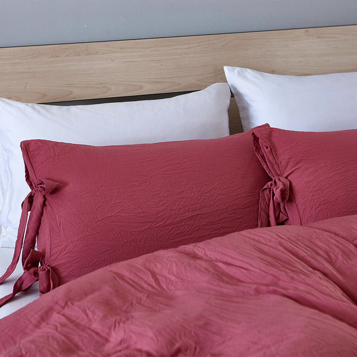 Close-up of the dusty rose pillowcase from the VibeCore Aesthetic Knot So Ordinary Duvet Cover Set, featuring a soft, textured fabric with unique knot edge detailing for an added cozy, stylish vibe to your bedroom or dorm. 
