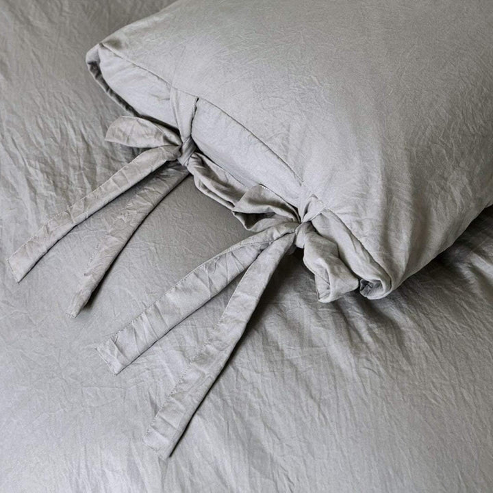 Close-up of the intricate knot detail on the light gray duvet cover from the VibeCore Aesthetic Knot So Ordinary Duvet Cover Set, highlighting the unique texture and stylish design for a cozy, chic bedroom or dorm look.