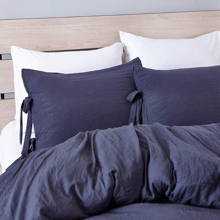 Close-up of the navy blue pillowcase from the VibeCore Aesthetic Knot So Ordinary Duvet Cover Set, featuring a soft, textured fabric with unique knot edge detailing for an added cozy, stylish vibe to your bedroom or dorm. 

