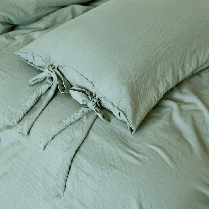Close-up of the pastel green pillowcase from the VibeCore Aesthetic Knot So Ordinary Duvet Cover Set, featuring a soft, textured fabric with unique knot edge detailing for an added cozy, stylish vibe to your bedroom or dorm. 
