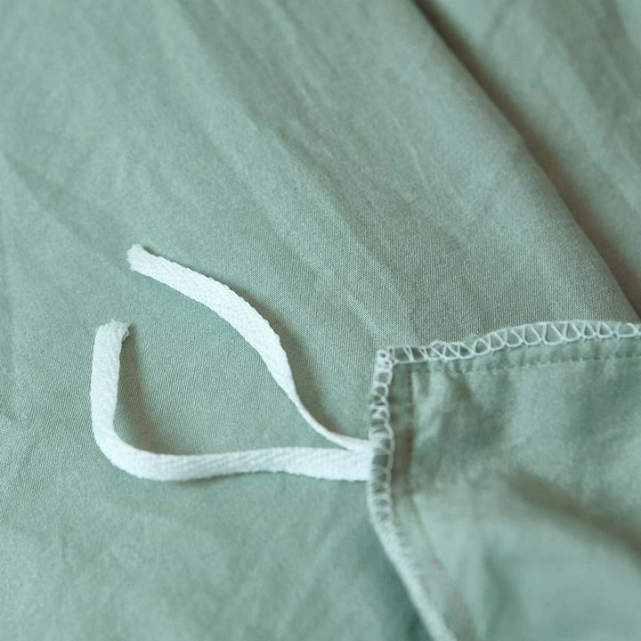 Close-up of the stylish tie feature on the pastel green duvet cover from the VibeCore Aesthetic Knot So Ordinary Duvet Cover Set, showcasing the trendy design detail that adds a unique, fashionable touch to your bedding.