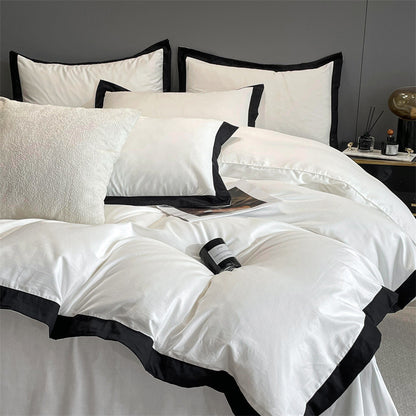 Close-up aerial view of the VibeCore Aesthetic Luxe Noir Trim Duvet Cover Set, featuring a sleek black trim that adds a touch of sophistication to the soft, luxurious fabric, perfect for elevating any bedroom or dorm aesthetic.