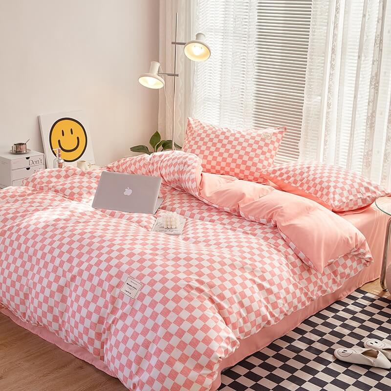 Right angle aerial view of the 'VibeCore Aesthetic Mini Checkered Duvet Cover Set' in Baby Pink, highlighting the modern checkered pattern and soft, durable fabric. The chic design and soothing lilac color add a fresh, contemporary touch to any bedroom or dorm.