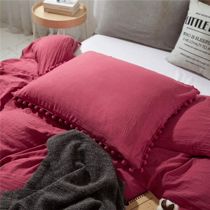 Close-up of the pompom pillowcase from the VibeCore Aesthetic PomPom Duvet Cover Set in dusty rose, featuring soft, playful pom-pom detailing. Crafted from soft, breathable fabric, this pillowcase adds a cozy, whimsical touch to any bedroom or dorm.