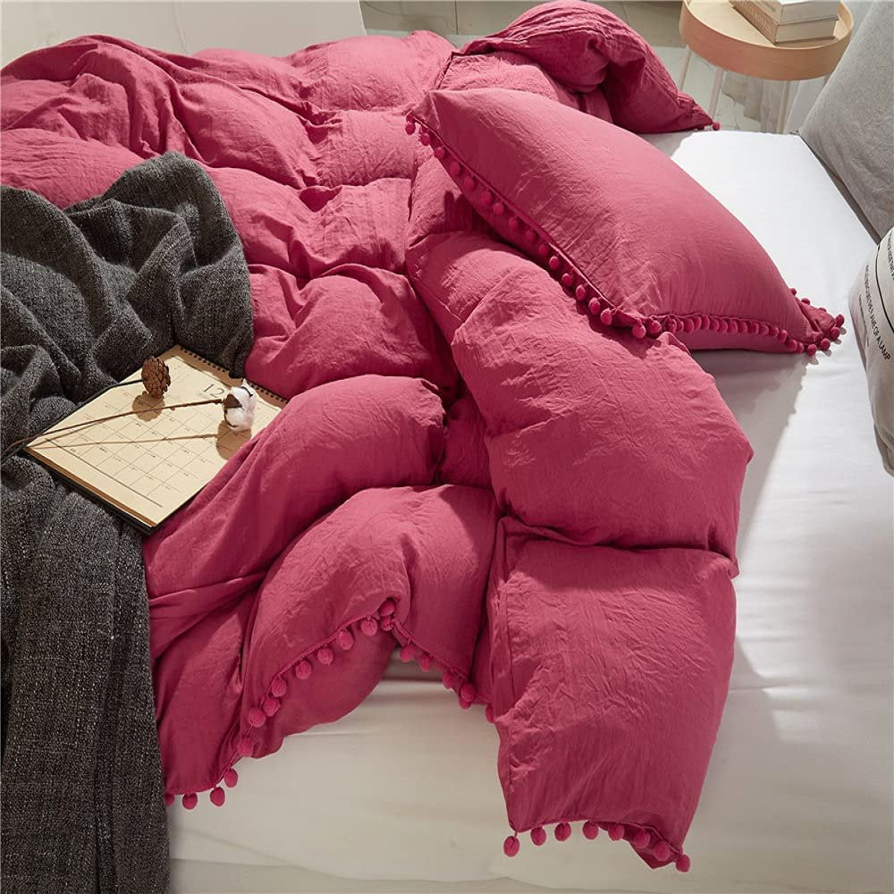 Side view of the VibeCore Aesthetic PomPom Duvet Cover Set in dusty rose, highlighting the playful pom-pom accents along the edges. Made from soft, breathable fabric, this duvet set adds a cozy, whimsical touch to any bedroom or dorm.
