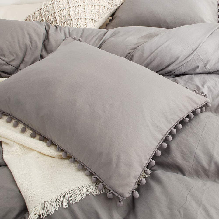Close-up of the pompom pillowcase from the VibeCore Aesthetic PomPom Duvet Cover Set in light gray, featuring soft, playful pom-pom detailing. Crafted from soft, breathable fabric, this pillowcase adds a cozy, whimsical touch to any bedroom or dorm.
