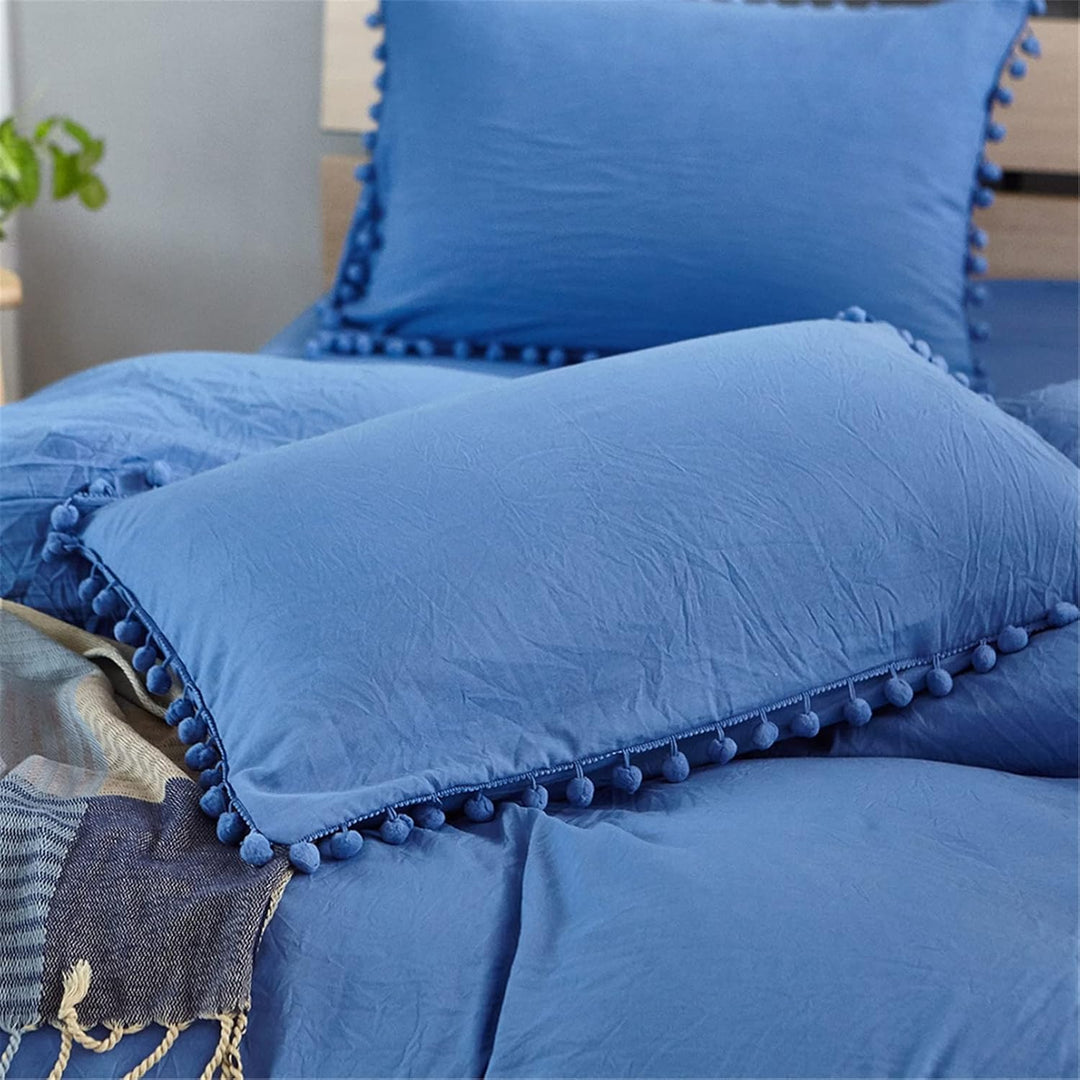 Close-up of the pompom pillowcase from the VibeCore Aesthetic PomPom Duvet Cover Set in navy blue, featuring soft, playful pom-pom detailing. Crafted from soft, breathable fabric, this pillowcase adds a cozy, whimsical touch to any bedroom or dorm.
