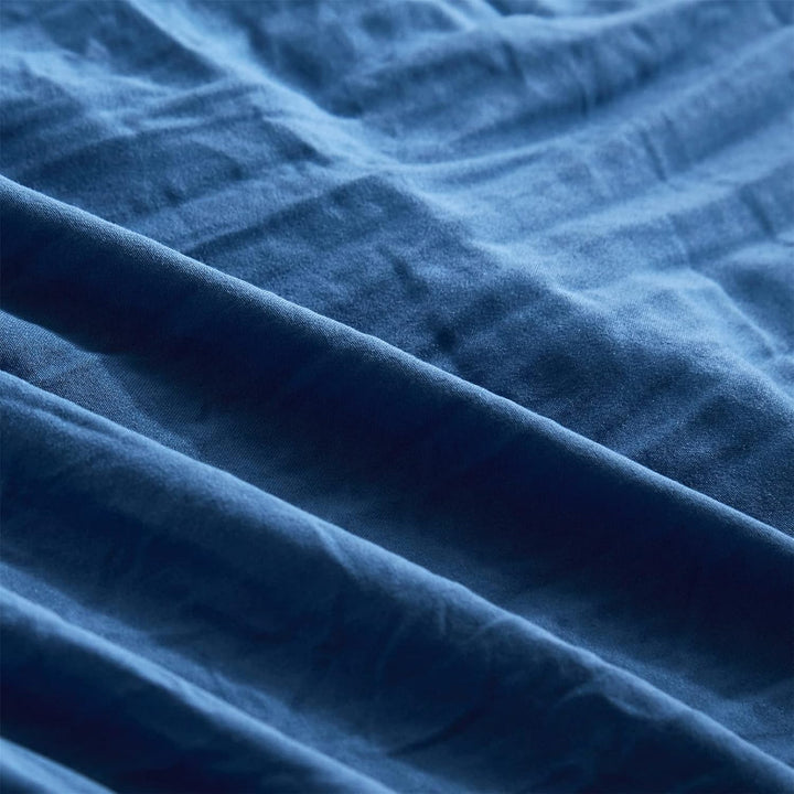 Close-up of the sheet from the VibeCore Aesthetic PomPom Duvet Cover Set in navy blue, featuring soft, subtle pom-pom detailing. Made from soft, breathable fabric, this sheet adds a cozy, playful touch to any bedroom or dorm with a bold, modern aesthetic.