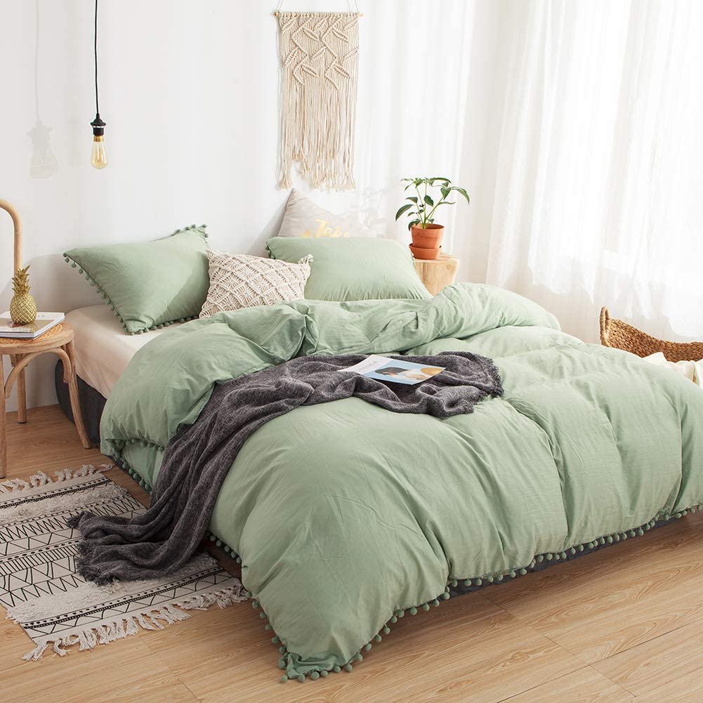 Aerial side view of the VibeCore Aesthetic PomPom Duvet Cover Set in pastel green, showcasing the soft pom-pom accents along the edges. Made from soft, breathable fabric, this duvet set brings a playful, cozy touch to any bedroom or dorm, with a fresh, light aesthetic.