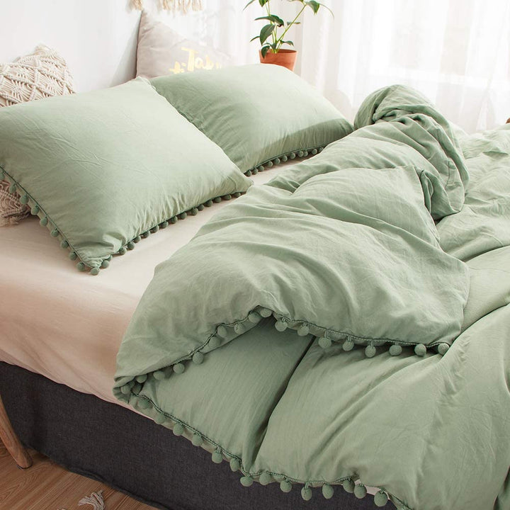 Close-up of the pompom detailing on the VibeCore Aesthetic PomPom Duvet Cover Set in pastel green, showcasing the soft, playful pom-pom accents that add texture and charm. Crafted from soft, breathable fabric, this duvet set brings a cozy, inviting touch to any bedroom or dorm.