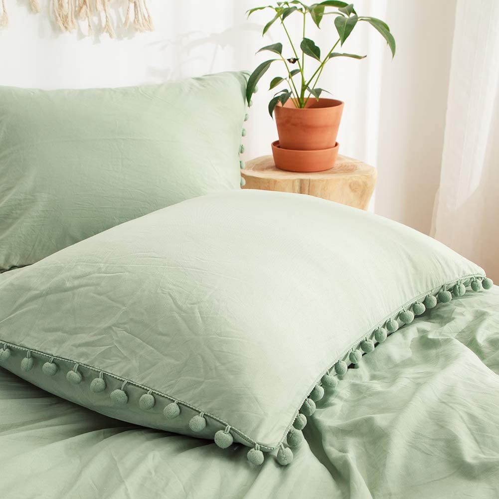 Close-up of the pompom pillowcase from the VibeCore Aesthetic PomPom Duvet Cover Set in pastel green, featuring soft, playful pom-pom detailing. Crafted from soft, breathable fabric, this pillowcase adds a cozy, whimsical touch to any bedroom or dorm.