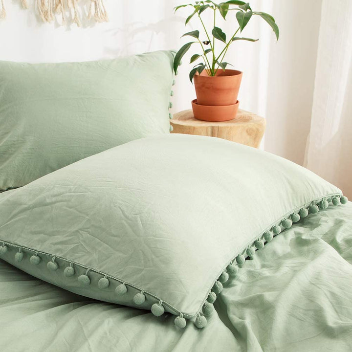 Close-up of the pompom pillowcase from the VibeCore Aesthetic PomPom Duvet Cover Set in pastel green, featuring soft, playful pom-pom detailing. Crafted from soft, breathable fabric, this pillowcase adds a cozy, whimsical touch to any bedroom or dorm.
