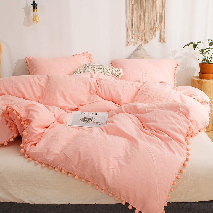 Close-up front view of the VibeCore Aesthetic PomPom Duvet Cover Set in rose, showcasing the soft, playful pom-pom detailing along the edges. Made from soft, breathable fabric, this duvet set adds a cozy, whimsical touch to any bedroom or dorm with its gentle, inviting hue.