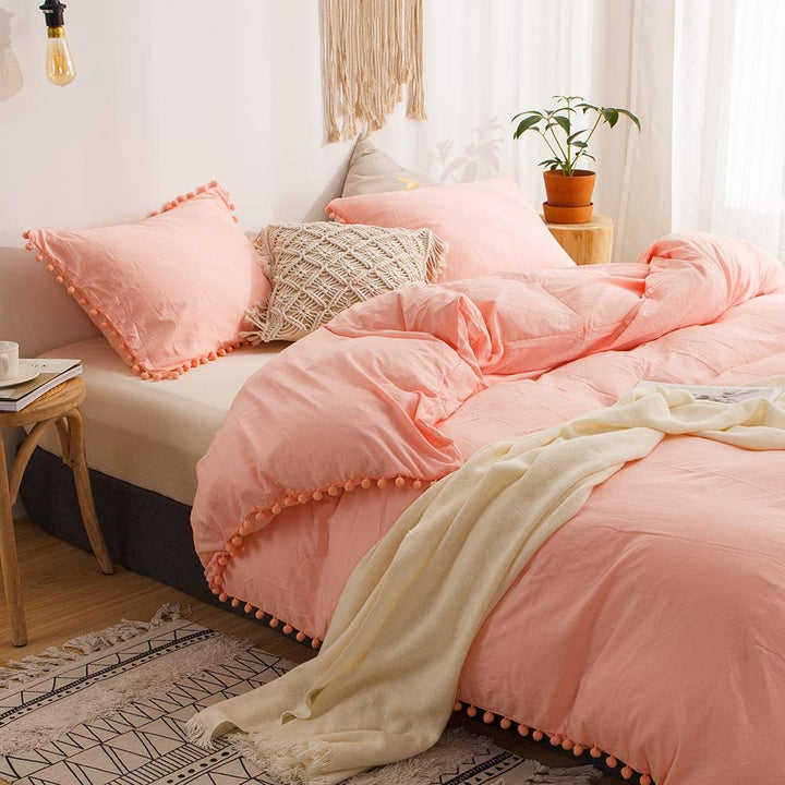 Side view of the VibeCore Aesthetic PomPom Duvet Cover Set in light gray, highlighting the playful pom-pom accents along the edges. Made from soft, breathable fabric, this duvet set adds a cozy, whimsical touch to any bedroom or dorm.