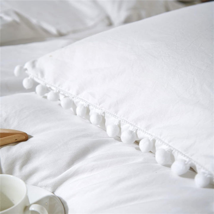 Close-up of the pompom detailing on the VibeCore Aesthetic PomPom Duvet Cover Set in white, showcasing the soft, playful pom-pom accents that add texture and charm. Crafted from soft, breathable fabric, this duvet set brings a cozy, inviting touch to any bedroom or dorm.