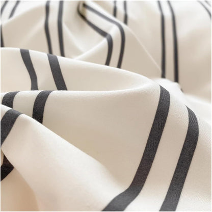 Super close-up of the black stripe pattern on a white backdrop on the 'VibeCore Urban Stripe Bedding Set,' highlighting the sharp, clean lines and soft texture of the fabric. The minimalist design offers a stylish, modern aesthetic for any bedroom.