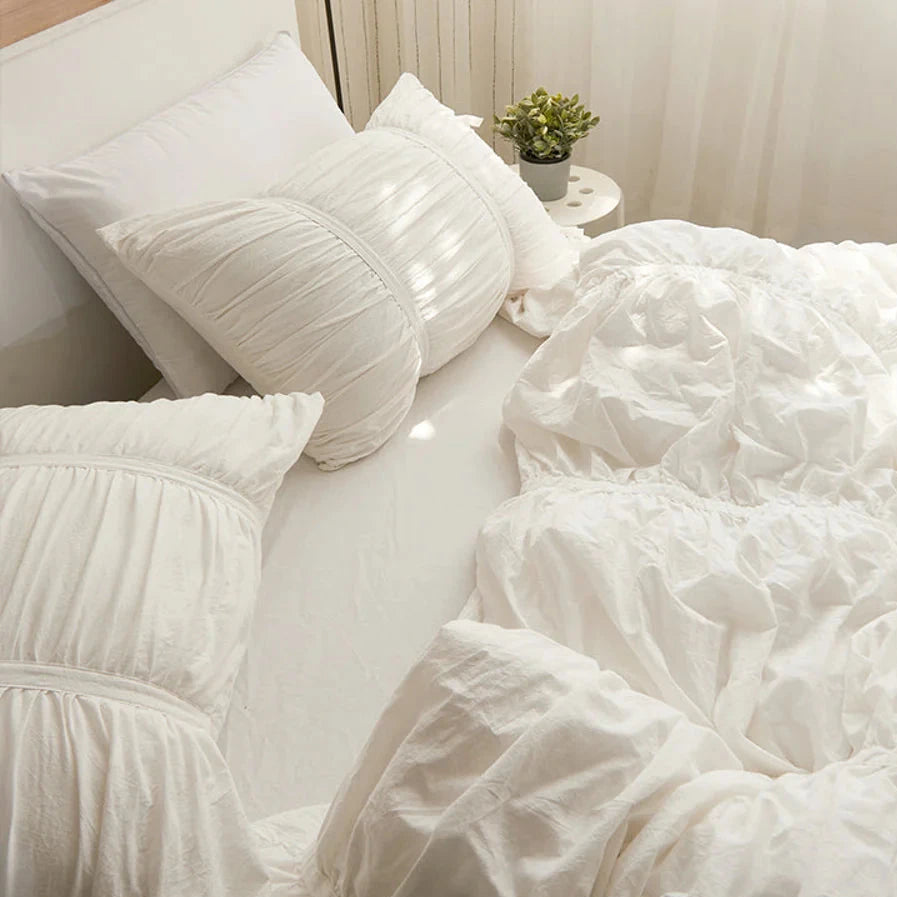 Aerial side view of the VibeCore White Timeless Elegance Pleated Bedding Set, highlighting the intricate pleated design on the duvet cover and pillowcases, offering a sophisticated and luxurious look.