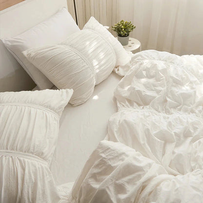 Aerial side view of the VibeCore White Timeless Elegance Pleated Bedding Set, highlighting the intricate pleated design on the duvet cover and pillowcases, offering a sophisticated and luxurious look.